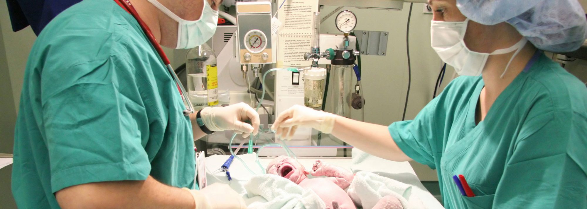 UConn Neonatal Nursing Online Master's Degree: Nurses taking care of baby in Neonatal unit.